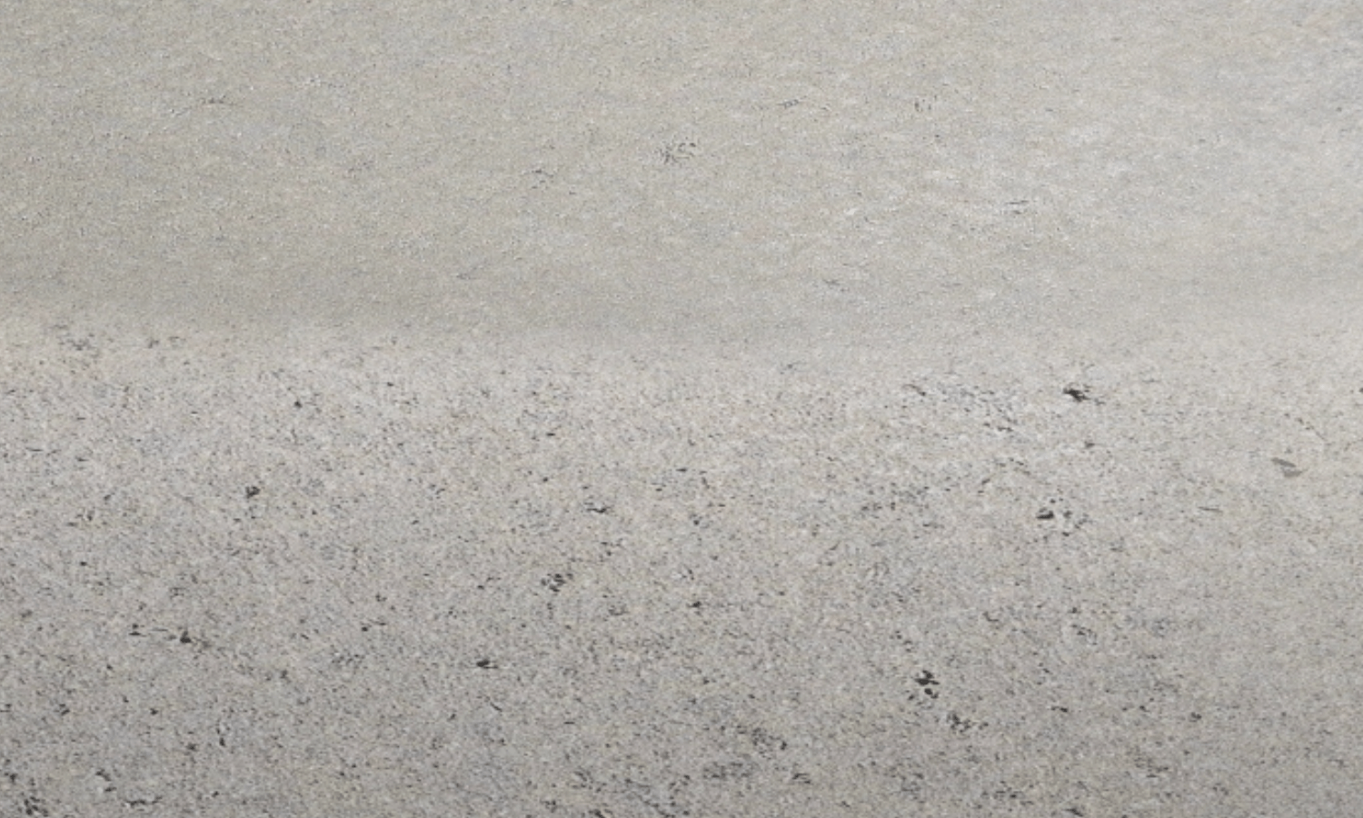 Close-up view of priming the concrete floor before soft floor covering installation
