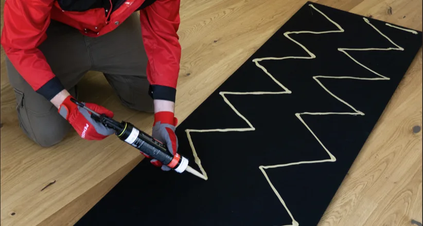 Applying PENOSIL adhesive in a zigzag bead onto a board