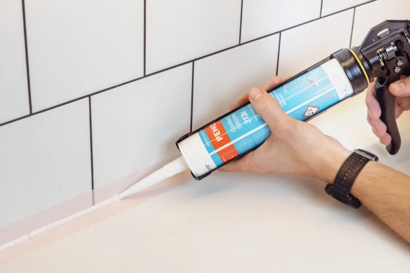Applying PENOSIL sealant along a tiled wall joint